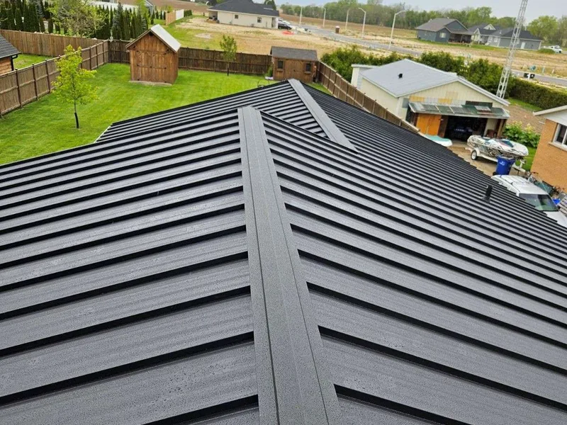 Close-up of a charcoal standing seam metal roof showing the interlocking seams