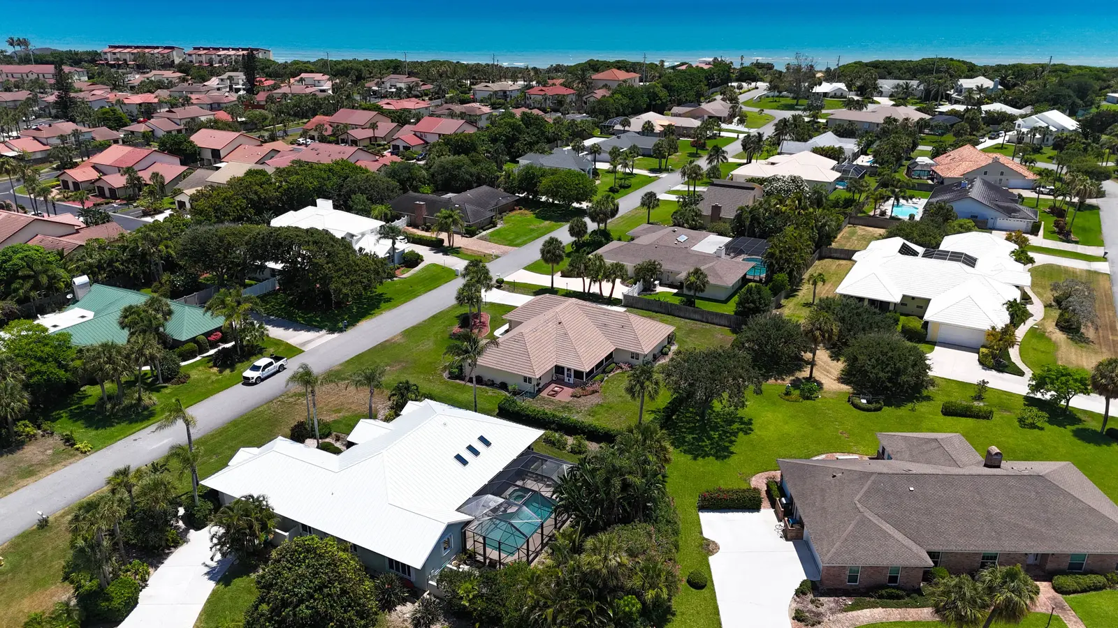 Aerial view of a white metal roof on a coastal Florida home near the ocean